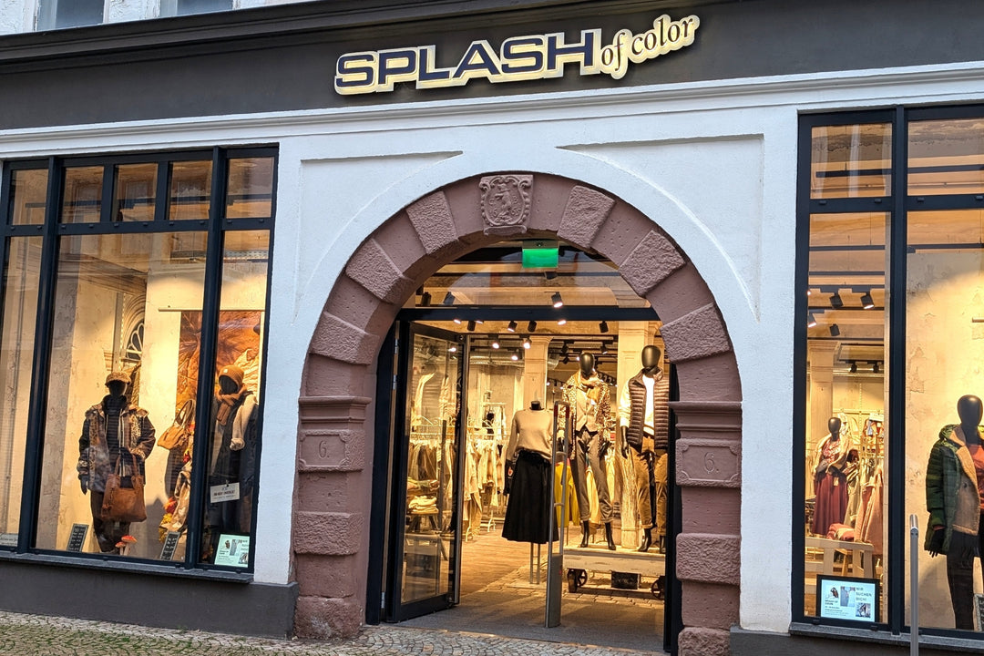 Außenansicht des Shops „SPLASH of Color“ mit Bogen und Schaufenstern